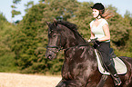 girl rides Friesian horse