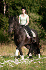 girl rides Friesian horse