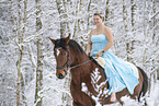 Woman riding through the snow in a dress