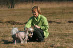 woman fondles Chinese Crested Dogs