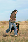 woman runs with Doberman Pinscher