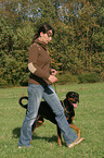 woman walks with Doberman Pinscher