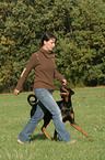 woman walks with Doberman Pinscher