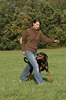 woman walks with Doberman Pinscher