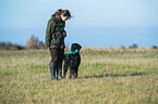 woman and Flat Coated Retriever
