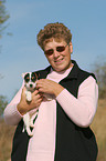 woman carries Jack Russell Terrier Puppy