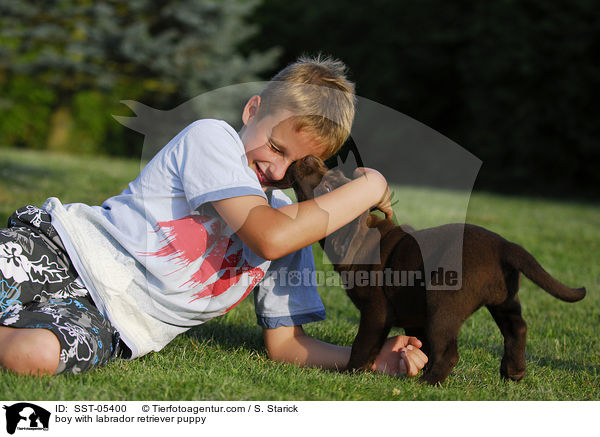Junge und Labrador Retriever Welpe / boy with labrador retriever puppy / SST-05400