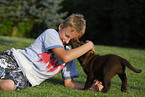 boy with labrador retriever puppy