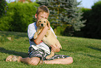 boy with labrador retriever puppy