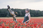 woman with  Malinois in the poppy field