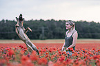 woman with  Malinois in the poppy field