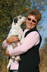 Parson Russell Terrier licks face of a woman
