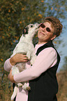 Parson Russell Terrier licks face of a woman