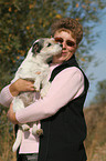 Parson Russell Terrier licks face of a woman