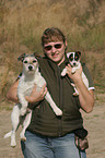 woman carries 2 Parson Russell Terrier