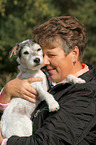 woman carries a Parson Russell Terrier