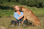 woman snuggles with Rhodesian Ridgeback