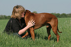 woman snuggles with Rhodesian Ridgeback