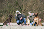 man and woman with 3 dogs