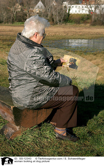 Frau schaut Hundefoto an / woman looking at dog picture / SS-12343