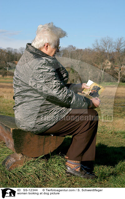 Frau schaut Hundefoto an / woman looking at dog picture / SS-12344