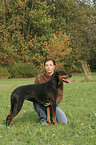 woman is fondling Doberman Pinscher