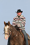 man rides American Paint Horse