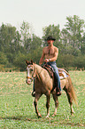 man rides American Paint Horse
