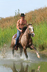 man rides American Paint Horse