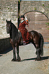 horsewoman with friesian horse and hawk