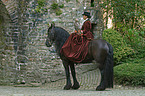 horsewoman with friesian horse and hawk
