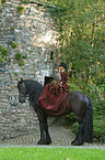 horsewoman with friesian horse and hawk