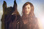 woman rides Frisian horse