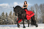 woman rides Frisian horse