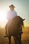 man rides Frisian horse