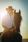 man rides Frisian horse