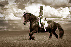 woman rides Frisian horse