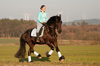 woman rides Frisian horse