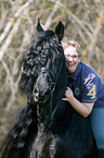 woman rides Frisian horse