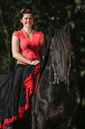 woman rides Friesian Horse
