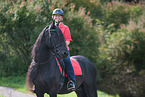 woman rides Friesian Horse