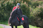 woman rides Friesian Horse