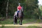 woman rides Friesian Horse