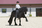 woman rides Friesian horse