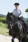 woman rides Friesian horse