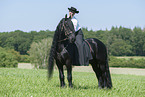 woman rides Friesian horse