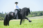 woman rides Friesian horse