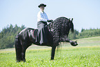 woman rides Friesian horse