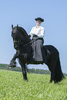 woman rides Friesian horse
