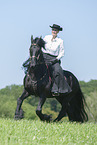 woman rides Friesian horse